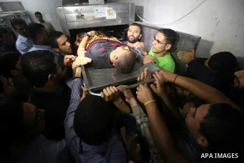 Palestinians youth carry the body at al-Shifa hospital morgue in Gaza City following Israeli shelling that killed several people as clashes erupted along the border on November 10, 2012. Israeli artillery fire killed sev...