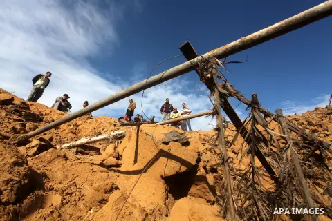 Palestinians inspect damage in their land damaged in an Israeli air strike in Gaza City November 13, 2012. The spike in violence, which comes as Israel is in the middle of an election campaign, raised the spectre of a br...