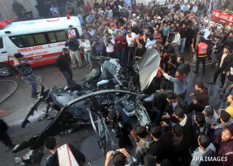Palestinian firefighters extinguish fire from the car of Ahmad Jaabari, head of the military wing of the Hamas movement, the Ezzedin Qassam Brigades, after it was hit by an Israeli air strike in Gaza City on November 14,...