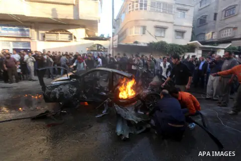 Palestinian firefighters extinguish fire from the car of Ahmad Jaabari, head of the military wing of the Hamas movement, the Ezzedin Qassam Brigades, after it was hit by an Israeli air strike in Gaza City on November 14,...