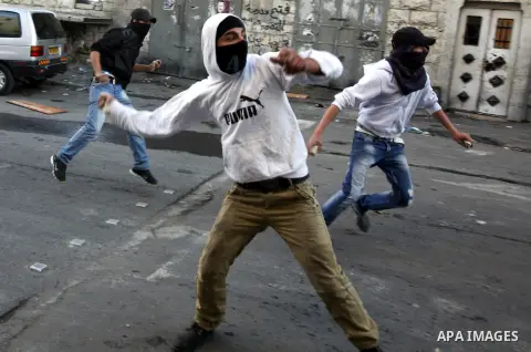 Palestinians throw stones at Israeli security forces (unseen) during clashes in protest to Israel's military operation in Gaza, in the East Jerusalem neighbourhood of Issawiya November 15, 2012. A Hamas rocket killed thr...