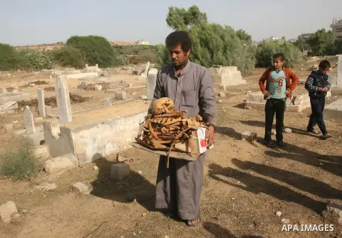 A Palestinian man carries bones from a grave after an Israeli airstrike on a cemetery in the southern of Gaza strip town of Rafah on November 16, 2012. Missiles continue to be fired on Israeli targets by Palestinian mili...