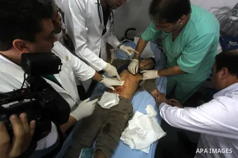 Palestinian doctors try to resuscitation a man injured in an Israeli air strike, during the visit by the Palestinian Prime Minister in the Gaza Strip Ismail Haniya and Egyptian Prime Minister Hisham Qandil (both unseen),...