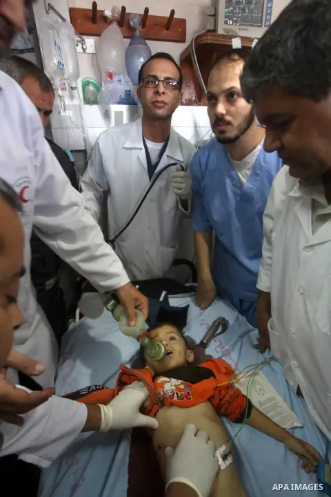 Palestinian doctors try to resuscitation a baby boy injured in an Israeli air strike, during the visit by the Palestinian Prime Minister in the Gaza Strip Ismail Haniya and Egyptian Prime Minister Hisham Qandil (both uns...