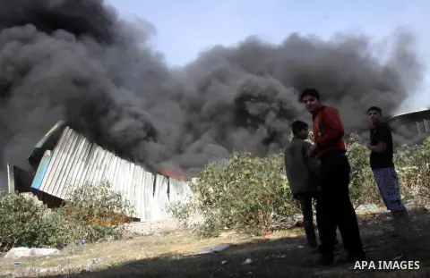 Palestinians stand near a factory which according to Palestinians was hit by an Israeli air strike in Gaza November 16, 2012. Egyptian Prime Minister Hisham Kandil arrived in the Gaza Strip on Friday to show solidarity w...