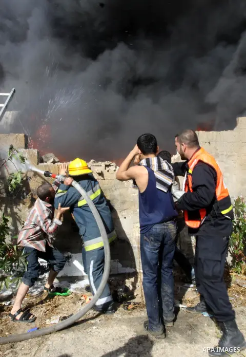 Firefighters try to extinguish a fire in a factory which according to Palestinians was hit by an Israeli air strike in Gaza November 16, 2012. Egyptian Prime Minister Hisham Kandil arrived in the Gaza Strip on Friday to...