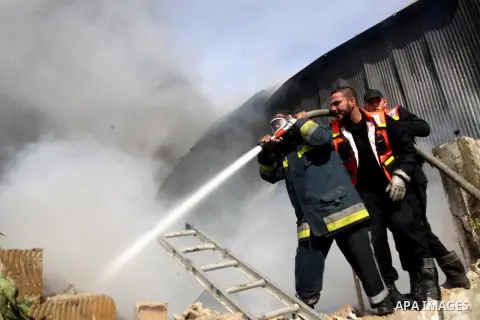 Firefighters try to extinguish a fire in a factory which according to Palestinians was hit by an Israeli air strike in Gaza November 16, 2012. Egyptian Prime Minister Hisham Kandil arrived in the Gaza Strip on Friday to...