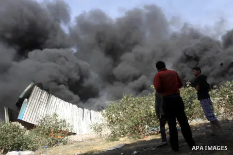 Palestinians stand near a factory which according to Palestinians was hit by an Israeli air strike in Gaza November 16, 2012. Egyptian Prime Minister Hisham Kandil arrived in the Gaza Strip on Friday to show solidarity w...