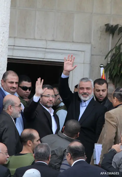 Palestinian Prime Minister in Gaza strip Ismail Haniyeh, right, and Egyptian Prime Minister Hesham Kandil, left, wave to the crowd as they meet in Gaza City, on November 16, 2012 . Egyptian premier Hisham Qandil vowed to...
