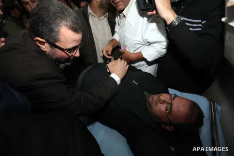 Palestinian Prime Minister in the Gaza Strip Ismail Haniyeh and Egypt's Prime Minister Hisham Kandil hold the hand of a patient, who was injured during an Israeli strike, during their visit to a hospital in Gaza City Nov...