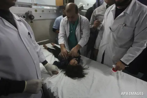 A Palestinian man carries an injured child into the treatment room of Shifa hospital following an Israeli airstrike, in Gaza City, Friday, Nov. 16, 2012. Fierce clashes between Israeli forces and Gaza militants are conti...