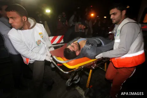 Palestinians carries an man into the treatment room of Shifa hospital following an Israeli airstrike, in Gaza City, Friday, Nov. 16, 2012. Fierce clashes between Israeli forces and Gaza militants are continuing for the t...