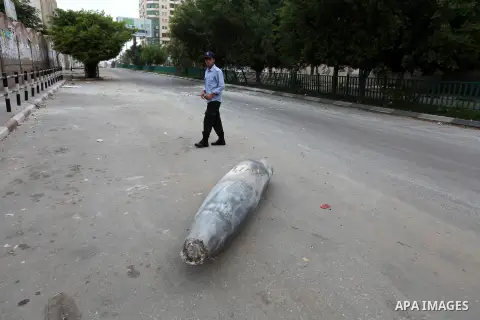 A Hamas policeman stands near an unexploded missile fired by an Israeli aircraft in Gaza City November 17, 2012. Israeli aircraft pounded Hamas government buildings in Gaza on Saturday, including the building housing the...