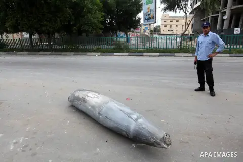A Hamas policeman stands near an unexploded missile fired by an Israeli aircraft in Gaza City November 17, 2012. Israeli aircraft pounded Hamas government buildings in Gaza on Saturday, including the building housing the...