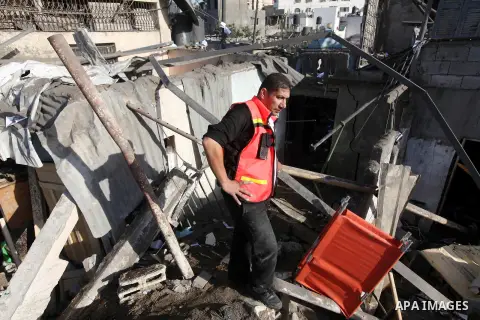 Palestinian civil defense staff use equipment to cut through metal as they search for victims stuck under the rubble of a destroyed house after it was damaged during an Israeli air strike on Gaza City on November 18, 201...