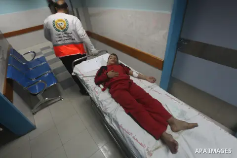Palestinian medics wheel a wounded boy on a stretcher to Al-Shifa hospital in Gaza City on November 18, 2012. An Israeli air strike hit a Gaza City media building on November 18, injuring at least six journalists, as a s...