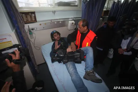 Palestinian medics treat a wounded Journalist on a stretcher to Al-Shifa hospital in Gaza City on November 18, 2012. An Israeli air strike hit a Gaza City media building on November 18, injuring at least six journalists,...