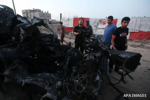 Palestinians gather arround a destroyed drinking water car which targeted by Israeli aircraft in the Jabaliya refugee camp, north of Gaza City, on Nov. 18, 2012. Ten Palestinian civilians were killed on Sunday in an Isra...