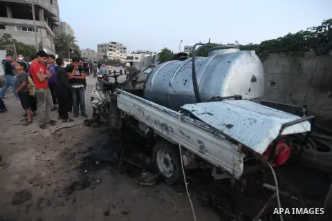 Palestinians gather arround a destroyed drinking water car which targeted by Israeli aircraft in the Jabaliya refugee camp, north of Gaza City, on Nov. 18, 2012. Ten Palestinian civilians were killed on Sunday in an Isra...