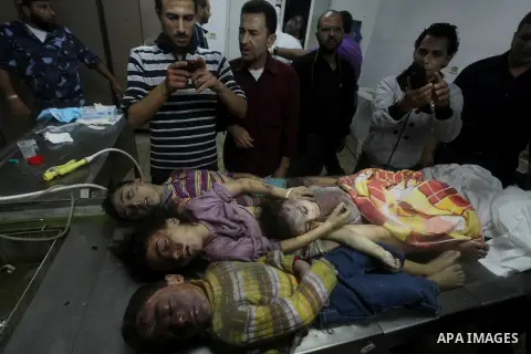 The bodies of four children from the al-Dallu family lay in a hospital after an Israeli missile struck a family home in Gaza City, on November 18, 2012. Ten Palestinian civilians were killed on Sunday in an Israeli air s...