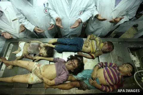 Palestinian doctors gather arround the bodies of four children from the al-Dallu family lay in a hospital after an Israeli missile struck a family home in Gaza City, on November 18, 2012. Ten Palestinian civilians were k...