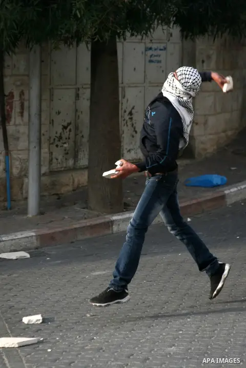 Palestinians in the West Bank city of Hebron protest by throwing stones against Israeli soldiers and security forces, 18 November 2012. Palestinians from the West Bank show their solidarity with Palestinians in the Gaza...
