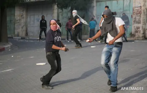 Palestinians in the West Bank city of Hebron protest by throwing stones against Israeli soldiers and security forces, 18 November 2012. Palestinians from the West Bank show their solidarity with Palestinians in the Gaza...
