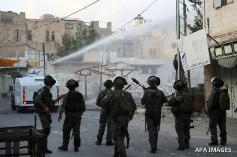 An Israeli truck spray foul smelling water towards Palestinian protesters in the West Bank city of Hebron, 18 November 2012. Palestinians from the West Bank show their solidarity with Palestinians in the Gaza Strip facin...
