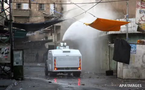 An Israeli truck spray foul smelling water towards Palestinian protesters in the West Bank city of Hebron, 18 November 2012. Palestinians from the West Bank show their solidarity with Palestinians in the Gaza Strip facin...