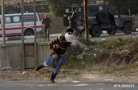 A Palestinian protester throws stones at Israeli soldiers during clashes following a protest against Israel's operations in the Gaza Strip, at Howwara checkpoint near Nablus, the West Bank, 18 November 2012. Reports stat...