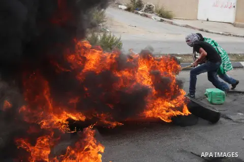 Palestinian protesters burn tires during clashes outside Ofer prison near the West Bank city of Ramallah November 18, 2012. The clashes broke out following a protest against Israel's military operation in the Gaza Strip....