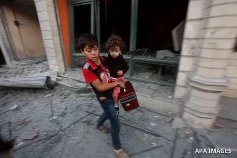 A Palestinian boy with his sister walk amongst the debris of destroyed homes following an Israeli air strike in Gaza City, on November 19, 2012. Israeli air strikes on Sunday killed 31 Palestinians in the bloodiest day s...