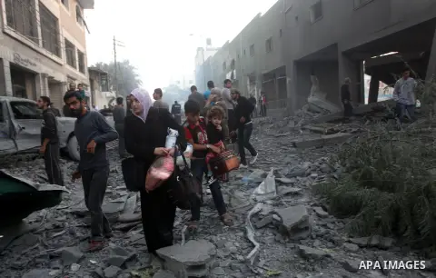 Palestinians walk amongst the debris of destroyed homes following an Israeli air strike in Gaza City, on November 19, 2012. Israeli air strikes on Sunday killed 31 Palestinians in the bloodiest day so far of its air camp...