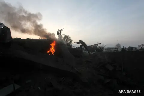 Palestinians try to extinguish a fire in a destroyed home following an Israeli air strike in Gaza City, on November 19, 2012. Israeli air strikes on Sunday killed 31 Palestinians in the bloodiest day so far of its air ca...
