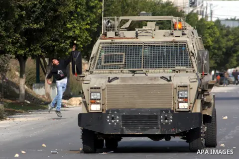 A Palestinian protester throws stones at Israeli soldiers during clashes following a protest against Israel's operations in the Gaza Strip, at Howwara checkpoint near Nablus, the West Bank, 17 November 2012. Reports stat...