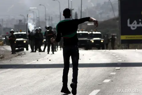 A Palestinian protester throws stones at Israeli soldiers during clashes following a protest against Israel's operations in the Gaza Strip, at Howwara checkpoint near Nablus, the West Bank, 17 November 2012. Reports stat...