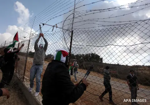 Palestinian youths cut a section of Israel's separation fence in the West Bank village of Ramat near Ramallah to protest against Israel's military action on the Gaza Strip, on November 19, 2012 . Israeli air strikes acro...