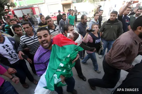 Palestinians carry the bodies of civilian from the al-Dallu family during their funeral in Gaza City, on November 19, 2012.Eleven members of the al-Dallu family were killed on Sunday when an Israeli missile struck the tw...
