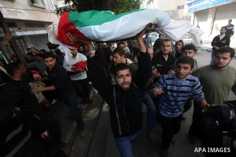 Palestinians carry the bodies of civilian from the al-Dallu family during their funeral in Gaza City, on November 19, 2012.Eleven members of the al-Dallu family were killed on Sunday when an Israeli missile struck the tw...