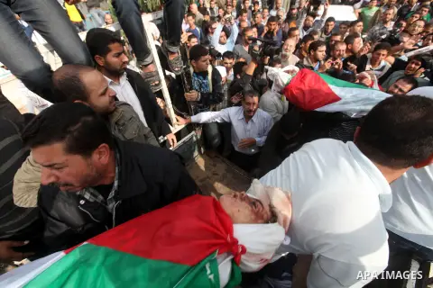 Palestinians carry the bodies of civilian from the al-Dallu family during their funeral in Gaza City, on November 19, 2012.Eleven members of the al-Dallu family were killed on Sunday when an Israeli missile struck the tw...
