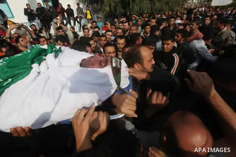 Palestinians carry the body of a member of Hamas militant Ezz el-Deen al-Qassam brigades during his funeral in Gaza City, on November 19, 2012. Media reports state that Israeli forces were on monday targeting the homes a...