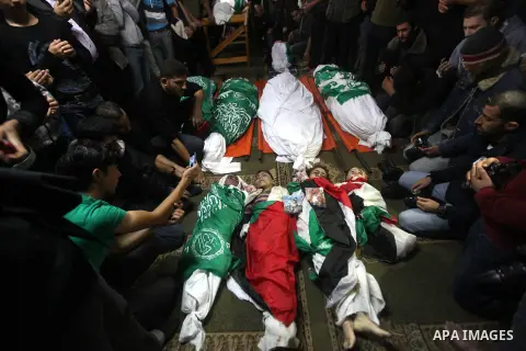 Palestinian mourners gather around the bodies of the al-Dallu family during their funeral in Gaza City, 19 November 2012. Nine members of the al-Dallu family died when Israeli forced hit their building in Gaza City one d...