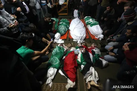 Palestinian mourners gather around the bodies of the al-Dallu family during their funeral in Gaza City, 19 November 2012. Nine members of the al-Dallu family died when Israeli forced hit their building in Gaza City one d...