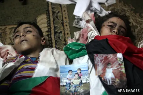 Palestinian mourners gather around the bodies of the al-Dallu family during their funeral in Gaza City, 19 November 2012. Nine members of the al-Dallu family died when Israeli forced hit their building in Gaza City one d...