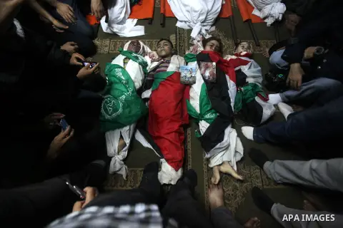 Palestinian mourners gather around the bodies of the al-Dallu family during their funeral in Gaza City, 19 November 2012. Nine members of the al-Dallu family died when Israeli forced hit their building in Gaza City one d...