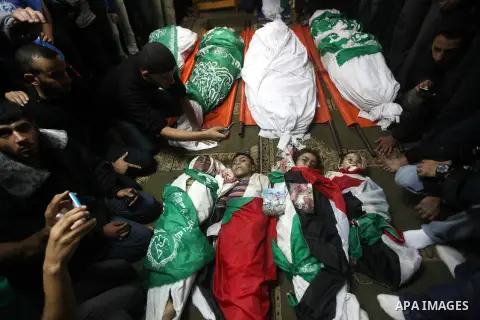 Palestinian mourners gather around the bodies of the al-Dallu family during their funeral in Gaza City, 19 November 2012. Nine members of the al-Dallu family died when Israeli forced hit their building in Gaza City one d...