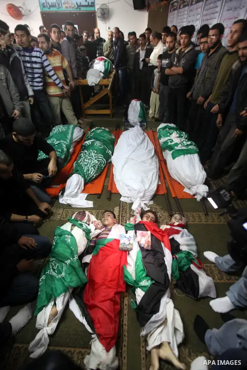 Palestinian mourners gather around the bodies of the al-Dallu family during their funeral in Gaza City, 19 November 2012. Nine members of the al-Dallu family died when Israeli forced hit their building in Gaza City one d...