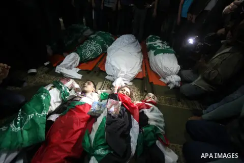 Palestinian mourners gather around the bodies of the al-Dallu family during their funeral in Gaza City, 19 November 2012. Nine members of the al-Dallu family died when Israeli forced hit their building in Gaza City one d...