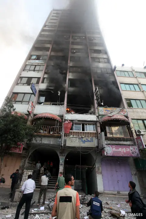 Palestinians inspect the damage after an Israeli air strike on al-Shorooq building in Gaza city, 19 November, 2012. Media reports that Israeli forces were on Monday targeting the Palestinian homes and other buildings in...