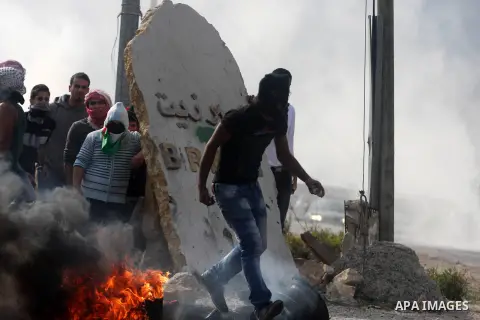 Palestinians take cover during minor clashes against Israel's military operation in the Gaza Strip, in the West Bank village of Birzeit, near Ramallah November 19, 2012. Israel bombed dozens of targets in Gaza on Monday...